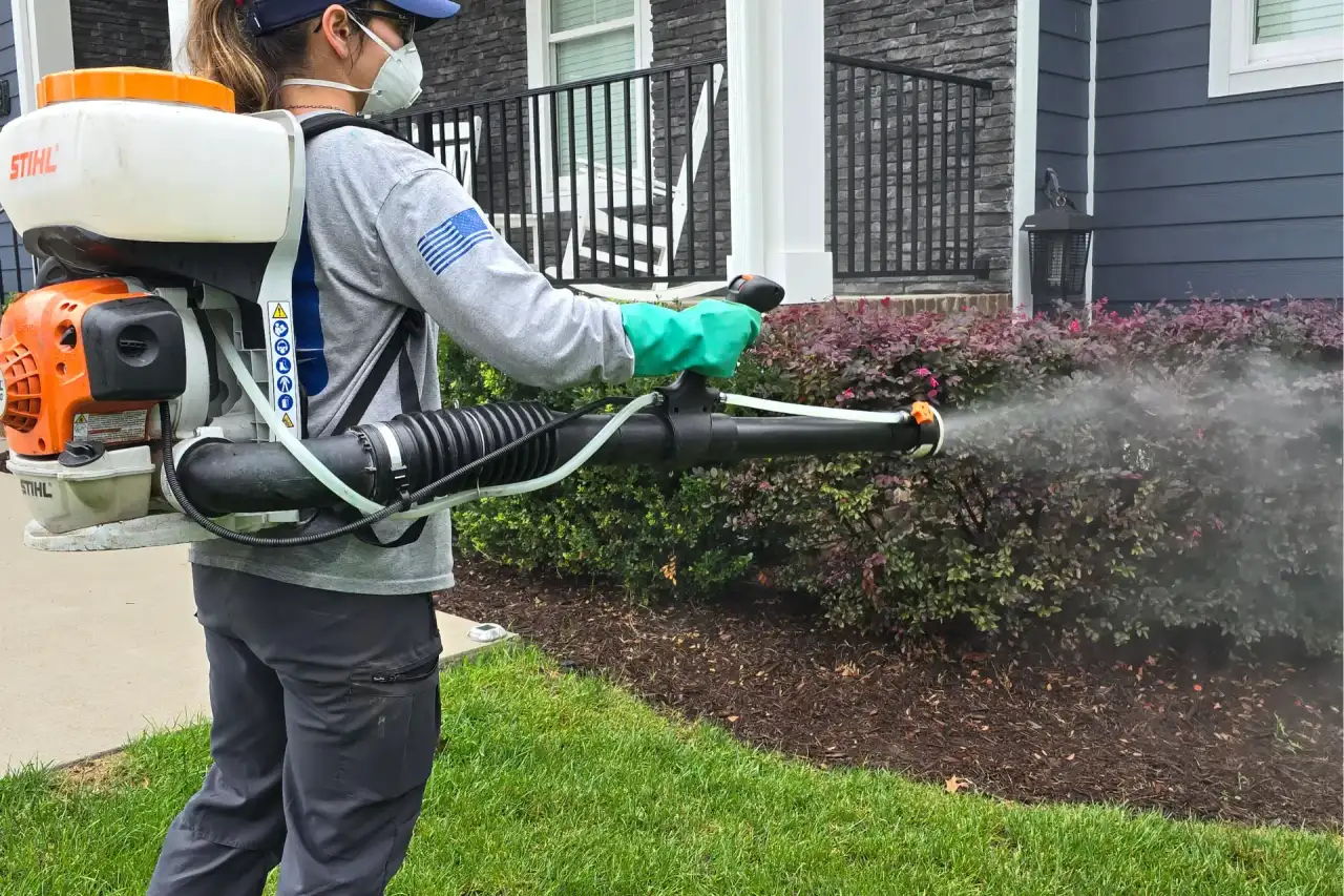 Mosquito barrier spray being applied to residential lawn